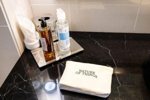 a bathroom counter with two bottles of perfume and a napkin at Voyage One Bedroom In Fairmont in Abu Dhabi