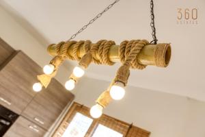 un lustre en corde avec des lumières suspendues au plafond dans l'établissement Charming 1BR APT with access to roof top terrace by 360 Estates, à San Ġiljan