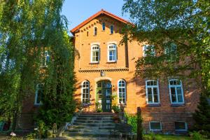 ein Backsteingebäude mit einer Treppe davor in der Unterkunft Gutshaus Zietlitz in Dobbin