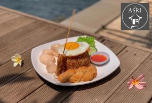 a plate of food on a wooden table at The Asri Villas in Jembrana
