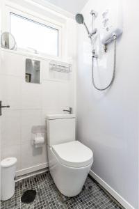 a white bathroom with a toilet and a shower at Park View in Great Yarmouth
