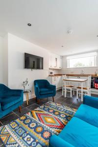 a living room with two blue chairs and a table at Park View in Great Yarmouth