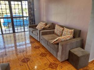 a living room with a couch and a table at COZYCRIB in Fort Portal