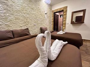 two swans sitting on a bed in a hotel room at Sahara Pyramids Inn in Cairo