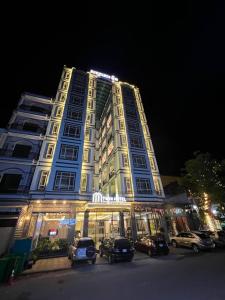 贡布Twin Hotel Kampot的一座大楼，前面停满了汽车