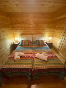 Una cama en una cabaña de madera con toallas. en Beautiful Chalet on Mt. Parnassos near ski resort en Kalánia