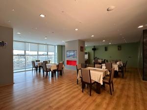a restaurant with tables and chairs in a room at MyHotel Erbil in Erbil