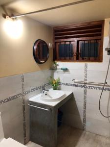 a bathroom with a sink and a mirror at Tiny Stay in Hikkaduwa