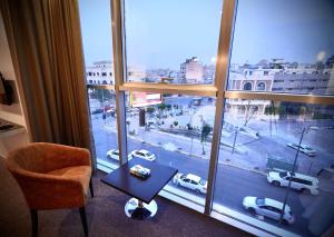 a room with a large window with a table and a chair at MyHotel Erbil in Erbil