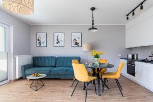 a living room with a blue couch and a table at Apartments with Parking - Klimaty Baltyku by Renters in Dziwnów