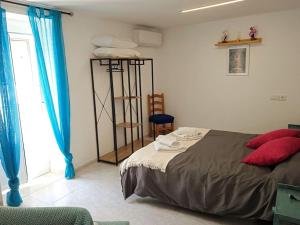 um quarto com uma cama com almofadas vermelhas e uma janela em Casa Cris Cazorla Oldtown II em Cazorla