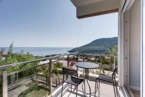 einen Balkon mit einem Tisch, Stühlen und Meerblick in der Unterkunft Begonvilla Apart Karaöz in Antalya