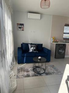 a living room with a blue couch and a table at The Abode in Gaborone