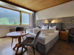 een slaapkamer met een bed, een tafel en een raam bij Pension Terra in Neustift im Stubaital