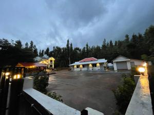 a parking lot at night with a building and trees at The Estate HomeStay in Attigundi +25 photos