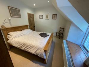 Schlafzimmer mit einem Bett und einem Holztisch in der Unterkunft Lovely listed cottage in old centre with garden. in Oundle