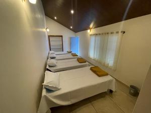 a row of beds in a room with a mirror at The Estate HomeStay in Attigundi