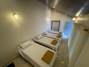 a room with four beds in it with lights at The Estate HomeStay in Attigundi