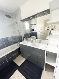 a bathroom with a sink and a mirror at Agréable et grande maison avec parking + jardin in Villeurbanne