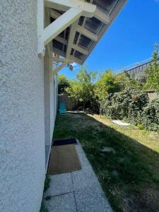 een veranda van een huis met een grasveld bij Agréable et grande maison avec parking + jardin in Villeurbanne