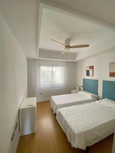 een slaapkamer met 2 bedden en een plafondventilator bij LUXURY Casares del Mar DBJ11 in Casares