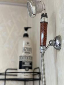 a shower head with a hose attached to a wall at Hello Hostel in Samarkand
