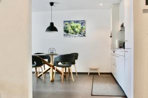 a kitchen and dining room with a table and chairs at Apartment Arvenwald in Kandersteg
