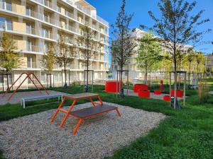 a playground with a bench and a swing at BA Apartment with free garage parking, huge outside area in Bratislava