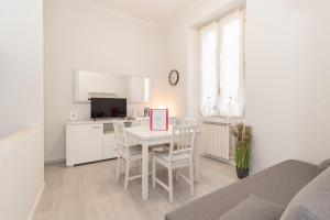 una cocina blanca con mesa y sillas en una habitación en Appartamento Porta Pile - F&L Apartment, en Brescia