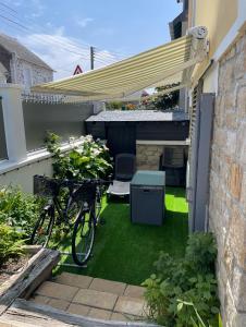 een fiets geparkeerd onder een luifel in een tuin bij STUDIO 3 Mn de la PLAGE Terrasse Vélos Proche de la ville fortifiée in Saint-Malo