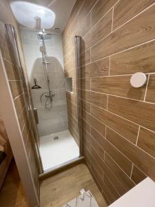 ein Bad mit einer ebenerdigen Dusche neben einer Dusche in der Unterkunft Au 35 in Millau