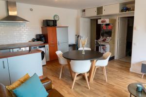 a kitchen and living room with a table and chairs at Escapade à la mer in Dunkerque +25 photos