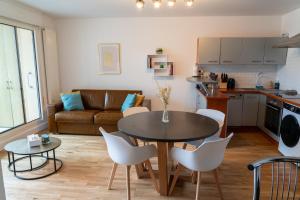 a kitchen and living room with a table and chairs at Escapade à la mer in Dunkerque