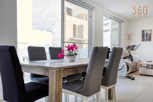 - une salle à manger avec une table et des chaises en bois dans l'établissement Lovely penthouse with private BBQ & WIFI in GZIRA BY 360 Estates, à Il-Gżira