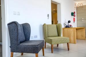 deux chaises assises l'une à côté de l'autre dans une pièce dans l'établissement Lovely penthouse with private BBQ & WIFI in GZIRA BY 360 Estates, à Il-Gżira