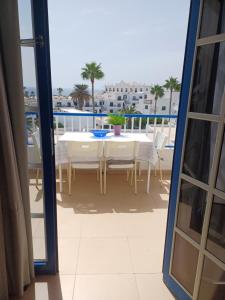 Habitación con vistas a un balcón con mesa y sillas. en T2 RESIDENCE ATALAYA PUERTO DEL CARMEN LANZAROTE, en Puerto del Carmen