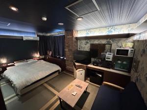 京都Hotel Sunday Brunch (Adult Only)的一间卧室，配有一张床和一张带电视的书桌