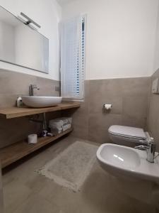 W łazience znajduje się umywalka, toaleta i lustro. w obiekcie B & B Ametista Bergamo w mieście Ponteranica