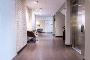 um corredor de escritório com paredes brancas e pisos de madeira em Good Morning+ Malmö em Malmo
