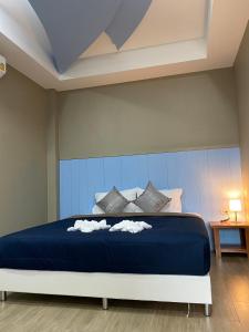 ein Schlafzimmer mit einem großen blauen Bett mit Kissen in der Unterkunft Greathill Gardenhome Resort Chomthong-Chiangmai in Chom Thong
