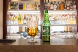 a bottle of beer and a glass on a bar at Good Morning+ Malmö in Malmö