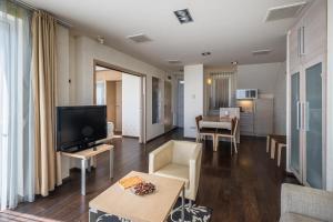 a living room with a flat screen tv and a couch at Echo Residence All Suite Hotel in Tihany