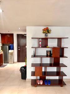 a living room with wooden shelves and a kitchen at Cubic P 1902 in Cebu City