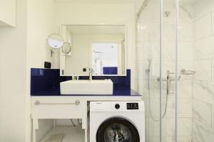 a washing machine in a bathroom with a mirror at Suites in Orbi City Batumi in Batumi