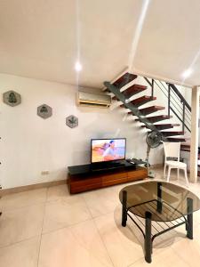 a living room with a tv and a spiral staircase at Cubic P 1902 in Cebu City
