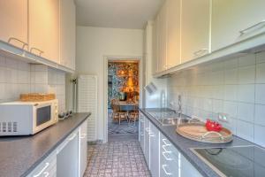 a kitchen with a microwave and a sink in it at Casa bambou in Liège