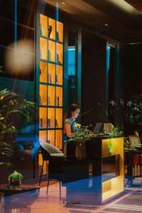 une femme assise sur un bureau avec un ordinateur portable dans l'établissement The Reserve - The Leading Hotels of the World - Savoy Signature, à Funchal