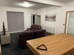 a living room with two chairs and a table at Seaside paradise in Bon-y-maen