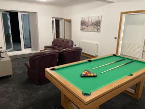 a living room with a pool table and chairs at Seaside paradise in Bon-y-maen