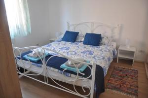 a white bed with blue pillows in a bedroom at Apartman Mirna in Rovinj